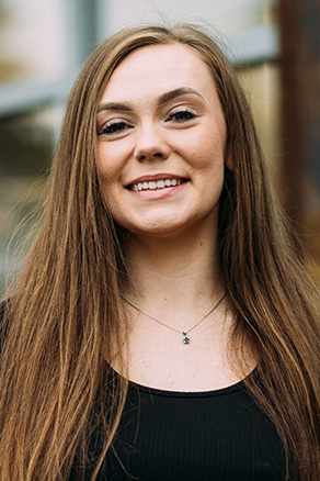 Female dental assistant in Burien, WA standing outside dental office